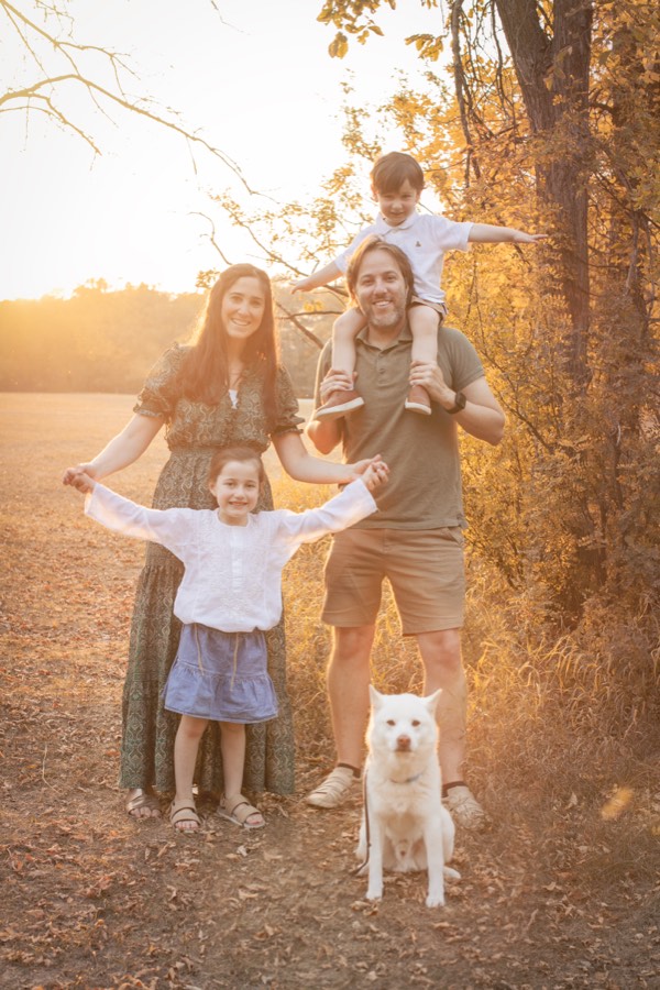 Family with their dog among golden trees