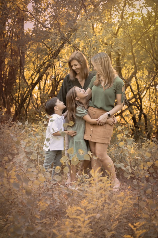Three generations together beneath golden trees